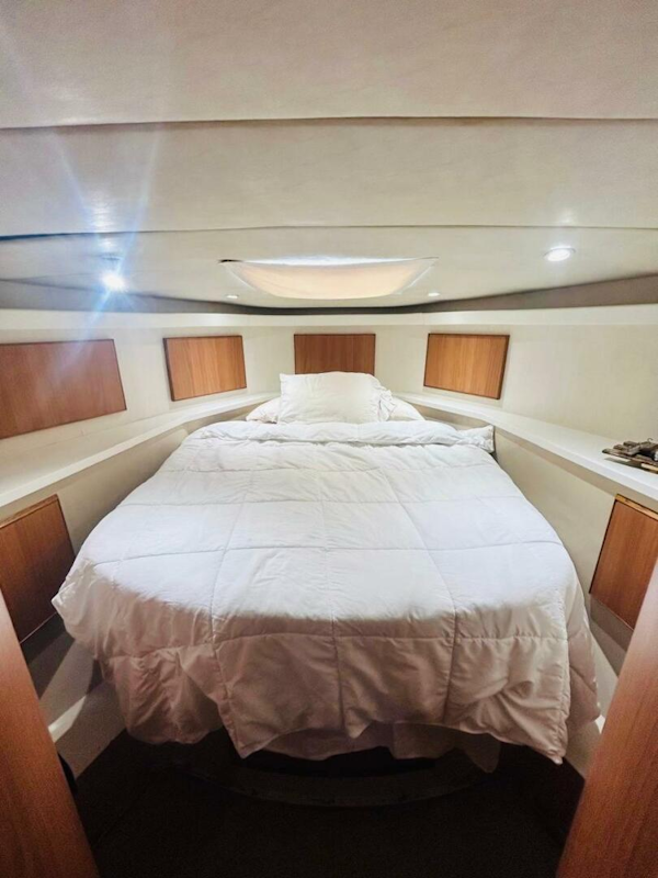 Bertram-54 1988 -Stuart-Cozy bedroom interior of 1988 Bertram 54 yacht with white bedding and wooden accents.-4947223