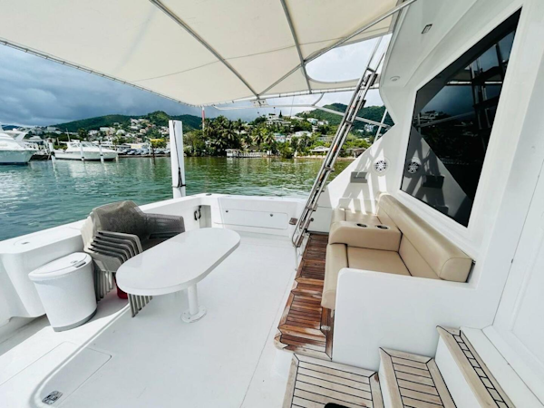 Bertram-54 1988 -Stuart-1988 Bertram 54 yacht deck with seating, table, and scenic marina view.-4947233