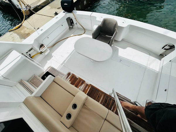 Bertram-54 1988 -Stuart-1988 Bertram 54 yacht deck with seating and table, docked at marina.-4947230