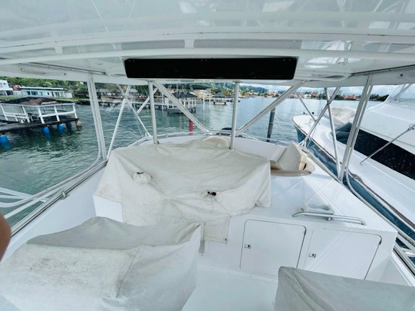 Bertram-54 1988 -Stuart-1988 Bertram 54 yacht deck with covered seating, docked at marina.-4947239