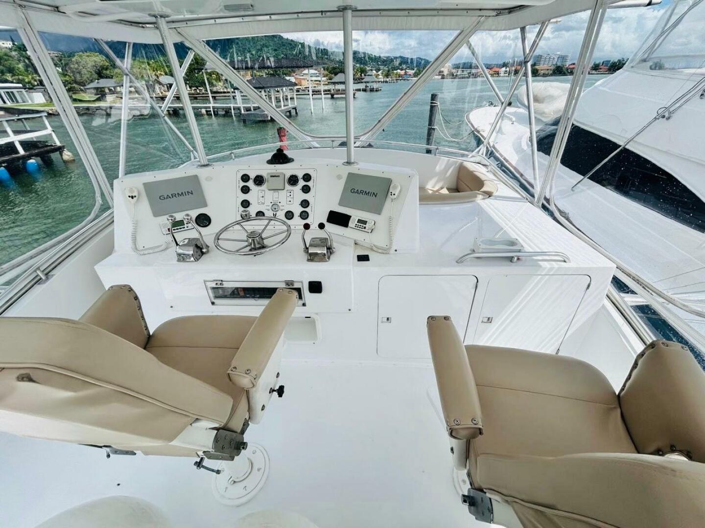 Bertram-54 1988 -Stuart-1988 Bertram 54 yacht helm with dual Garmin displays and beige captain chairs.-4947242 | Thumbnail