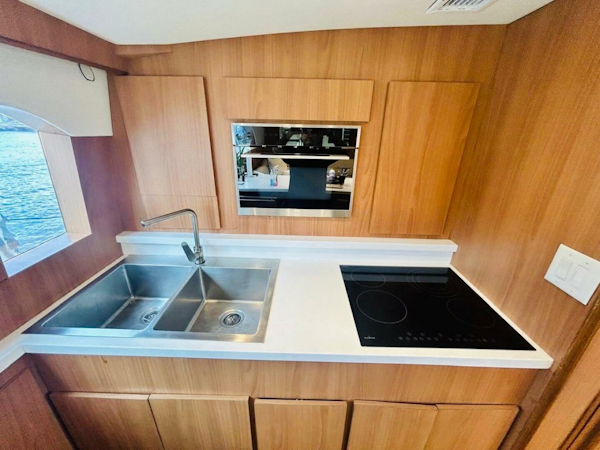 Bertram-54 1988 -Stuart-1988 Bertram 54 yacht kitchen with dual sink and electric cooktop.-4947229