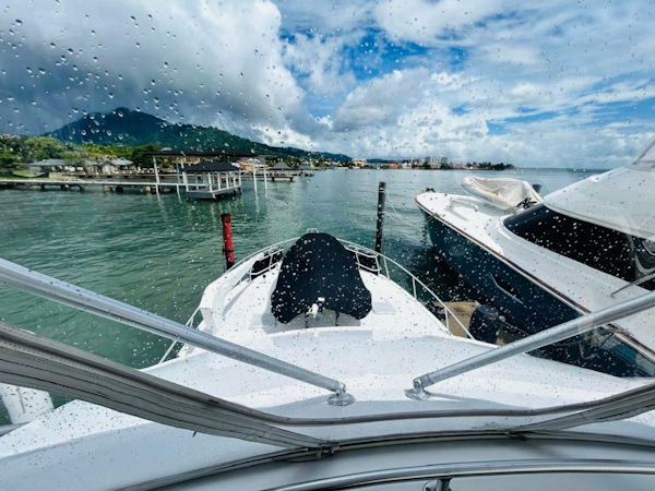 Bertram-54 1988 -Stuart-1988 Bertram 54 yacht docked in scenic marina, viewed through rain-speckled window.-4947202