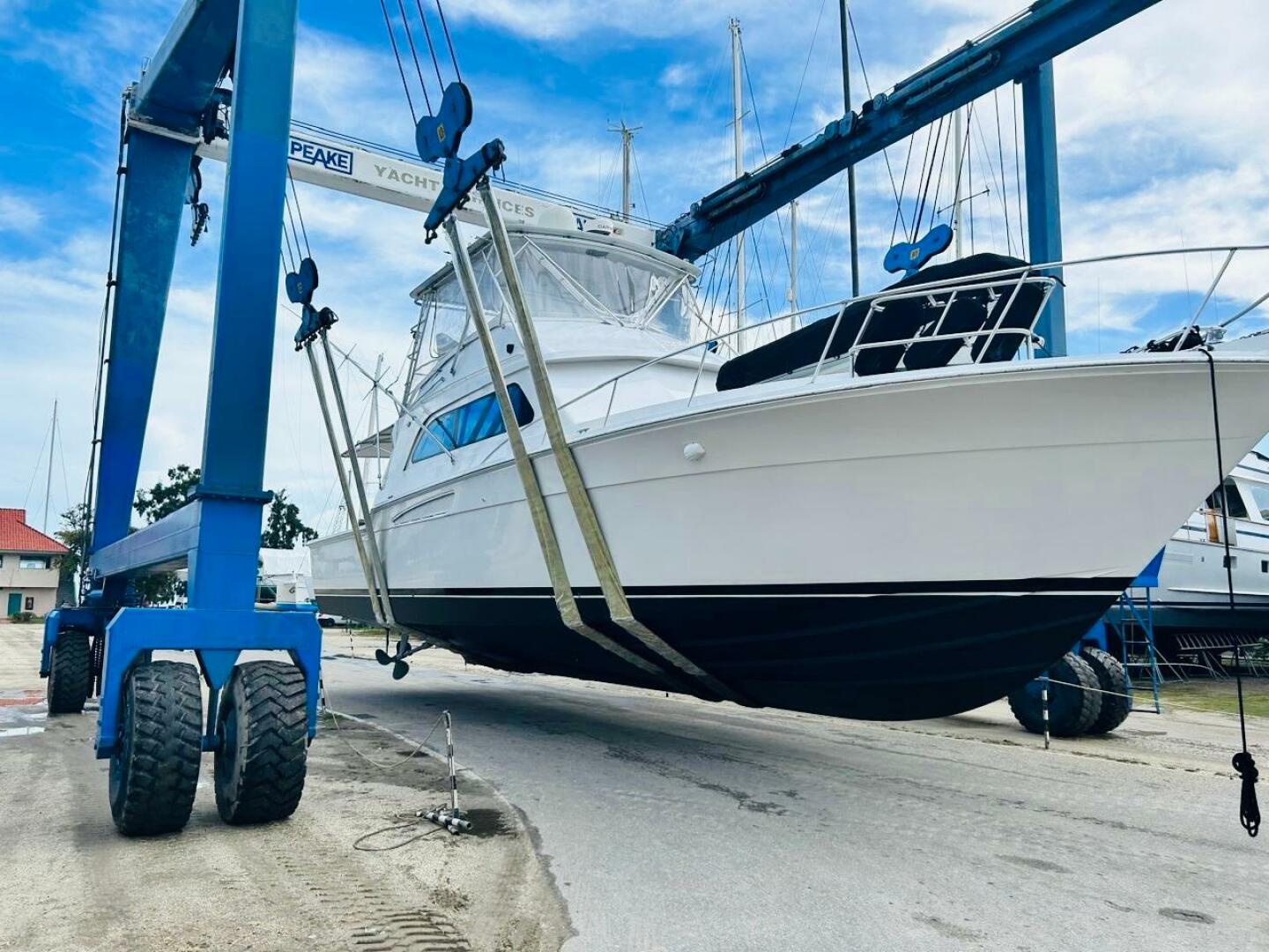 Bertram-54 1988 -Stuart-1988 Bertram 54 yacht being lifted by a boat hoist at a marina.-4947207 | Thumbnail