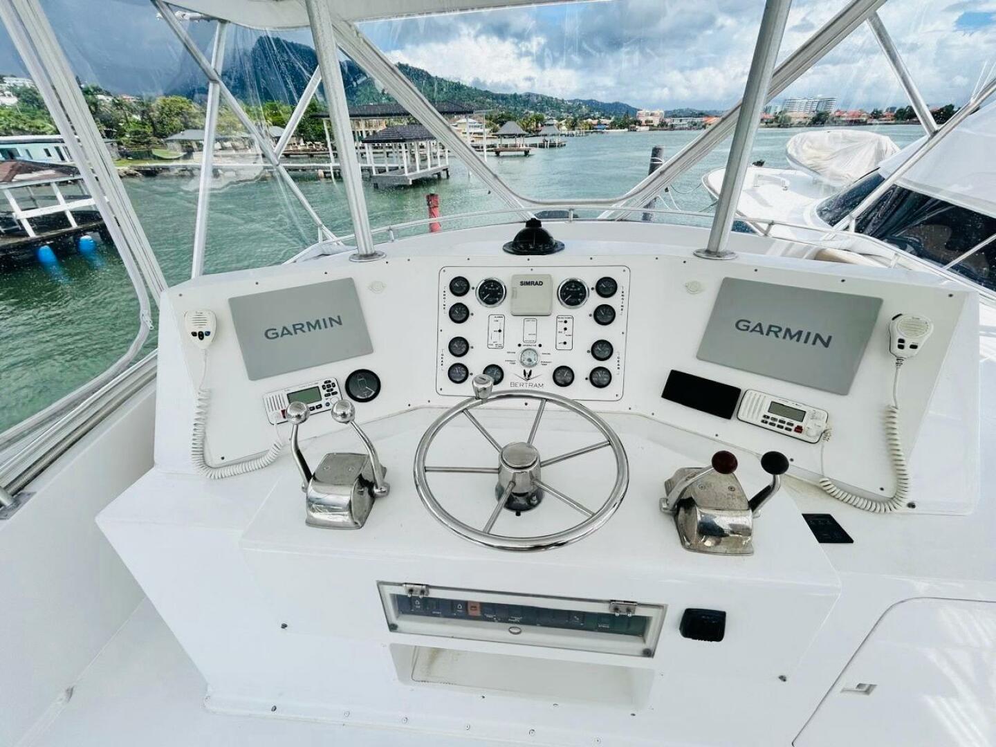 Bertram-54 1988 -Stuart-1988 Bertram 54 yacht helm with Garmin navigation, dual controls, and scenic marina view.-4947243 | Thumbnail