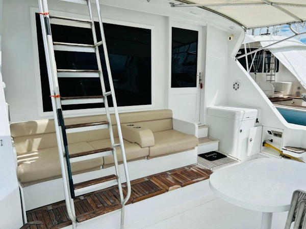 Bertram-54 1988 -Stuart-1988 Bertram 54 yacht deck with seating, ladder, and table.-4947224