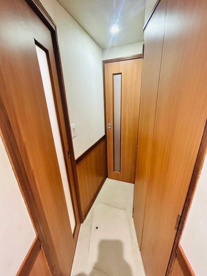 Bertram-54 1988 -Stuart-Interior hallway of 1988 Bertram 54 yacht with wooden doors and soft lighting.-4947231 | Thumbnail