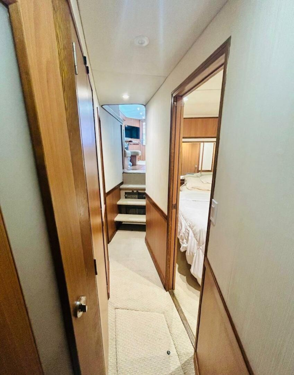 Bertram-54 1988 -Stuart-1988 Bertram 54 yacht interior hallway with wood paneling and bedroom view.-4947228