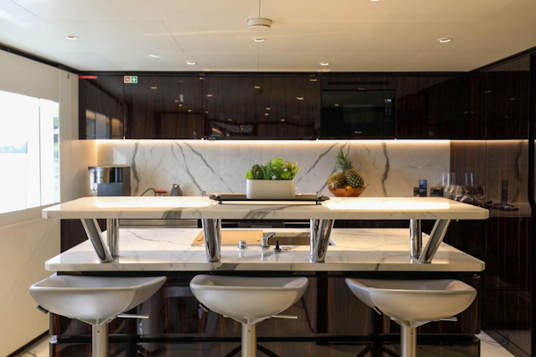 Majesty Yachts-120 2025-Fractional Ownership Available Stuart-Florida-United States-Luxurious yacht kitchen with marble countertops, modern stools, and elegant cabinetry, Majesty 120, 2025.-4947540