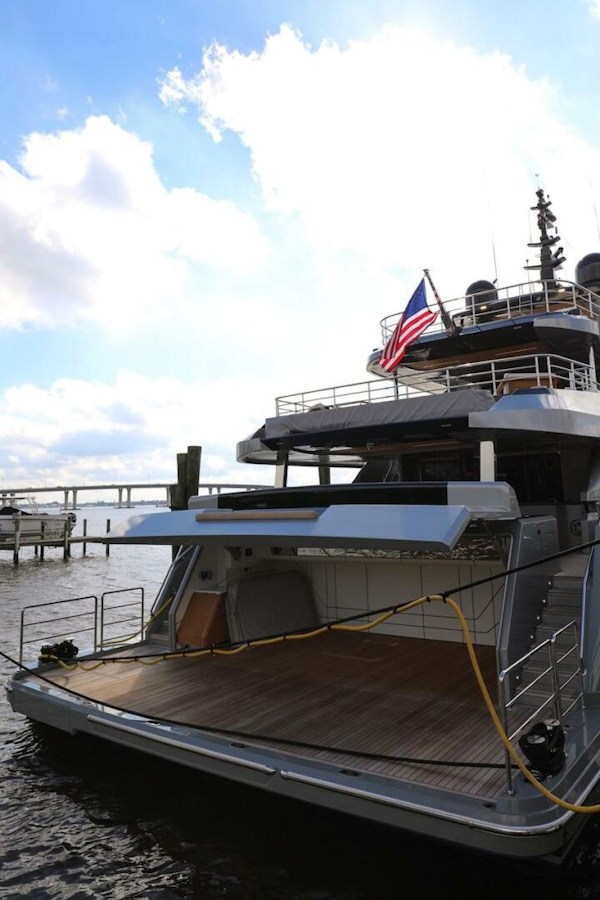 Majesty Yachts-120 2025-Fractional Ownership Available Stuart-Florida-United States-Luxury Majesty 120 yacht, 2025 model, docked with American flag, under a bright sky.-4947532
