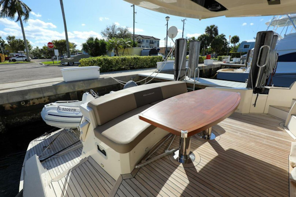 Marquis-660 Sport Yacht 2016 -Stuart-2016 Marquis 660 Sport Yacht deck with seating and table, docked in a sunny marina.-4947634