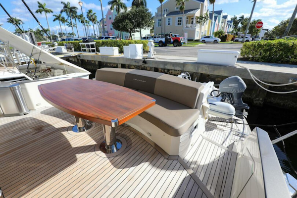Marquis-660 Sport Yacht 2016 -Stuart-2016 Marquis 660 Sport Yacht deck with seating and table, docked near palm trees.-4947633