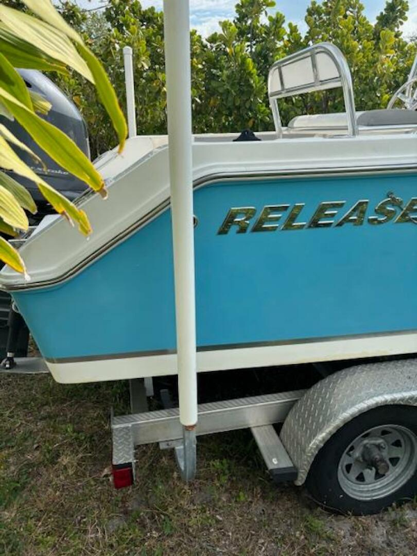 Release-208 RX 2016 -Stuart-2016 Release 208 RX boat on trailer, blue and white design, parked outdoors.-5114918