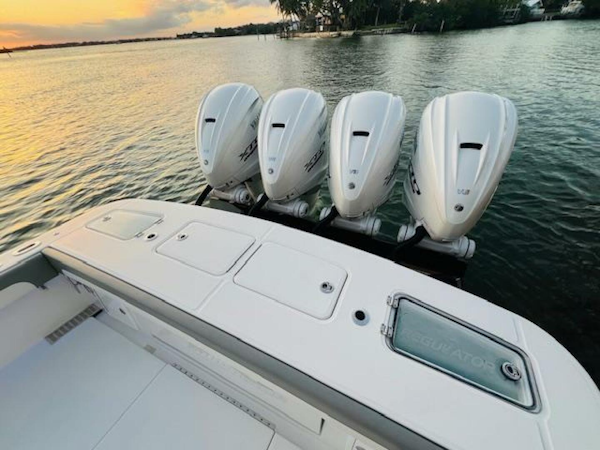 Regulator-41 2024-Fractional Ownership Available Stuart-2024 Regulator 41 boat with four powerful outboard engines on a serene water backdrop.-5234055