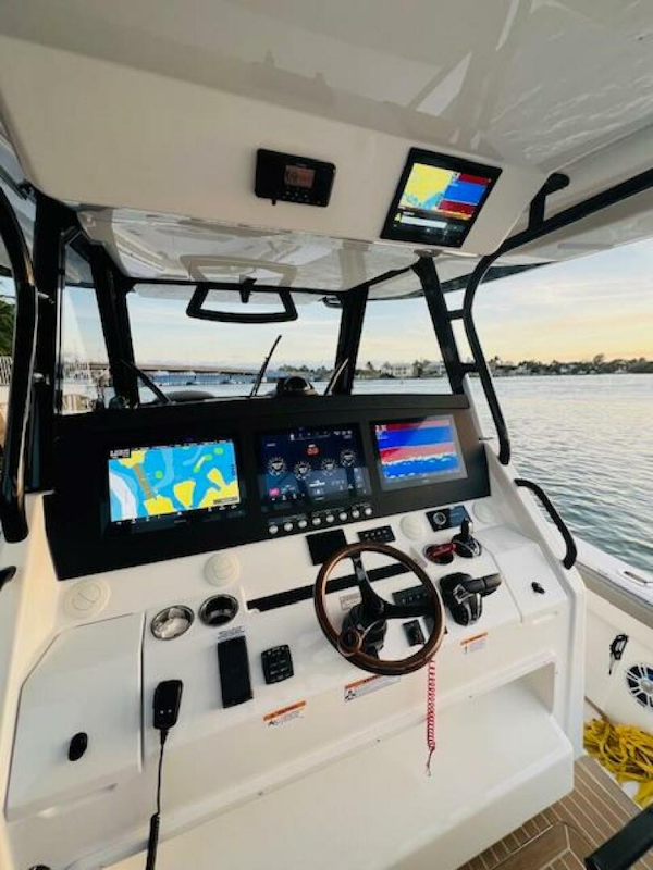 Regulator-41 2024-Fractional Ownership Available Stuart-2024 Regulator 41 boat cockpit with advanced navigation displays at sunset.-5234053