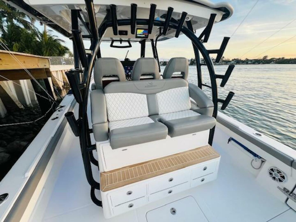Regulator-41 2024-Fractional Ownership Available Stuart-2024 Regulator 41 boat interior with cushioned seating and rod holders by the water.-5234054
