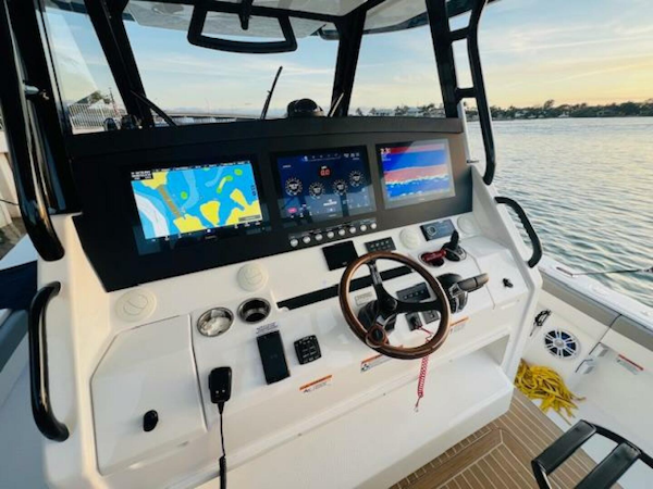 Regulator-41 2024-Fractional Ownership Available Stuart-2024 Regulator 41 boat dashboard with advanced navigation screens and controls, overlooking serene waters.-5234051