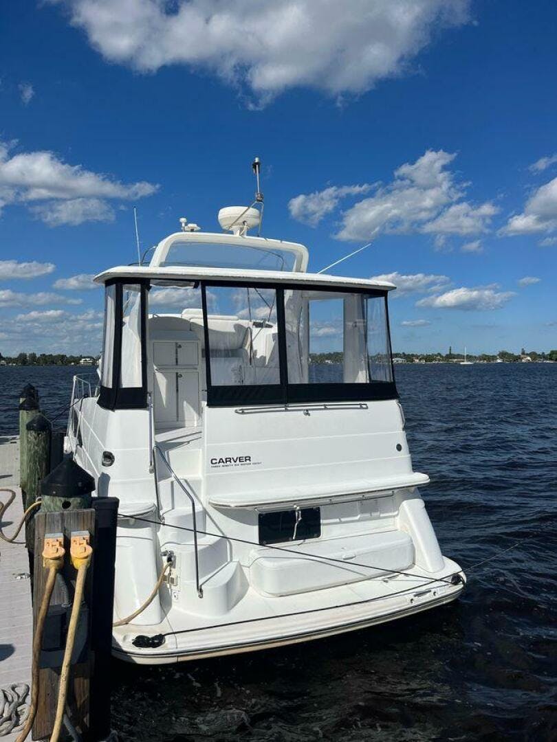 Carver-396 Motor Yacht 2000 -Stuart-2000 Carver 396 Motor Yacht docked by a scenic waterfront under a clear blue sky.-5234106