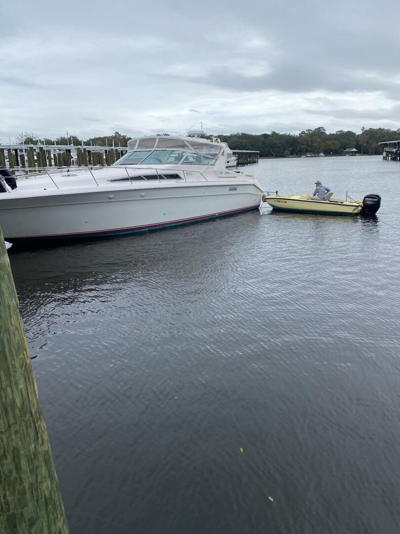Sea Ray-440 Sundancer 1993 -Stuart-1993 Sea Ray 440 Sundancer docked beside a small yellow boat on a cloudy day.-5268592 | Thumbnail