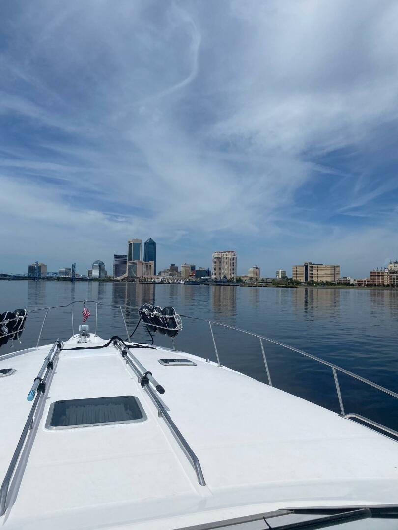 Sea Ray-440 Sundancer 1993 -Stuart-1993 Sea Ray 440 Sundancer cruising towards city skyline under blue sky.-5268582 | Thumbnail