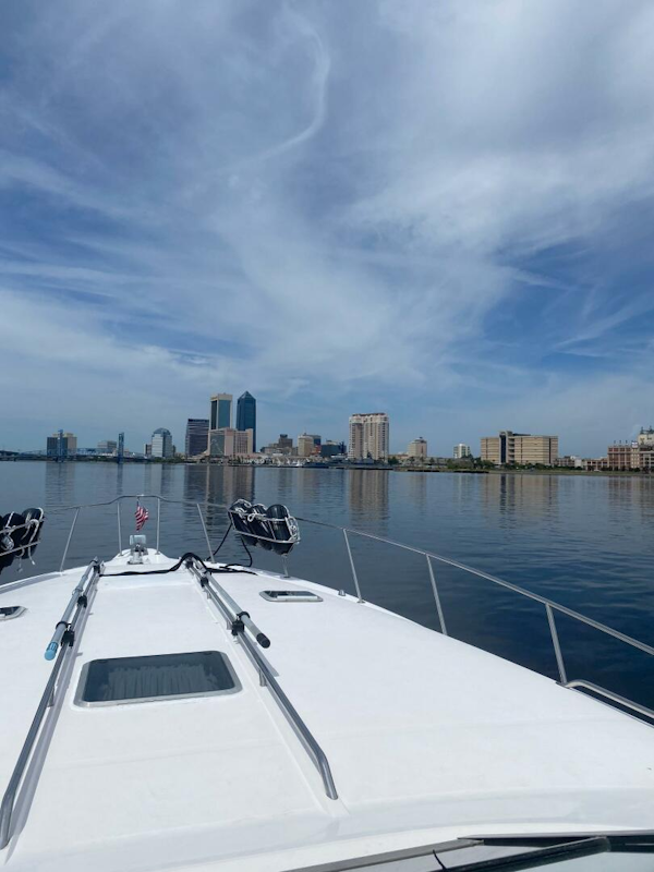 Sea Ray-440 Sundancer 1993 -Stuart-1993 Sea Ray 440 Sundancer cruising towards city skyline under blue sky.-5268582