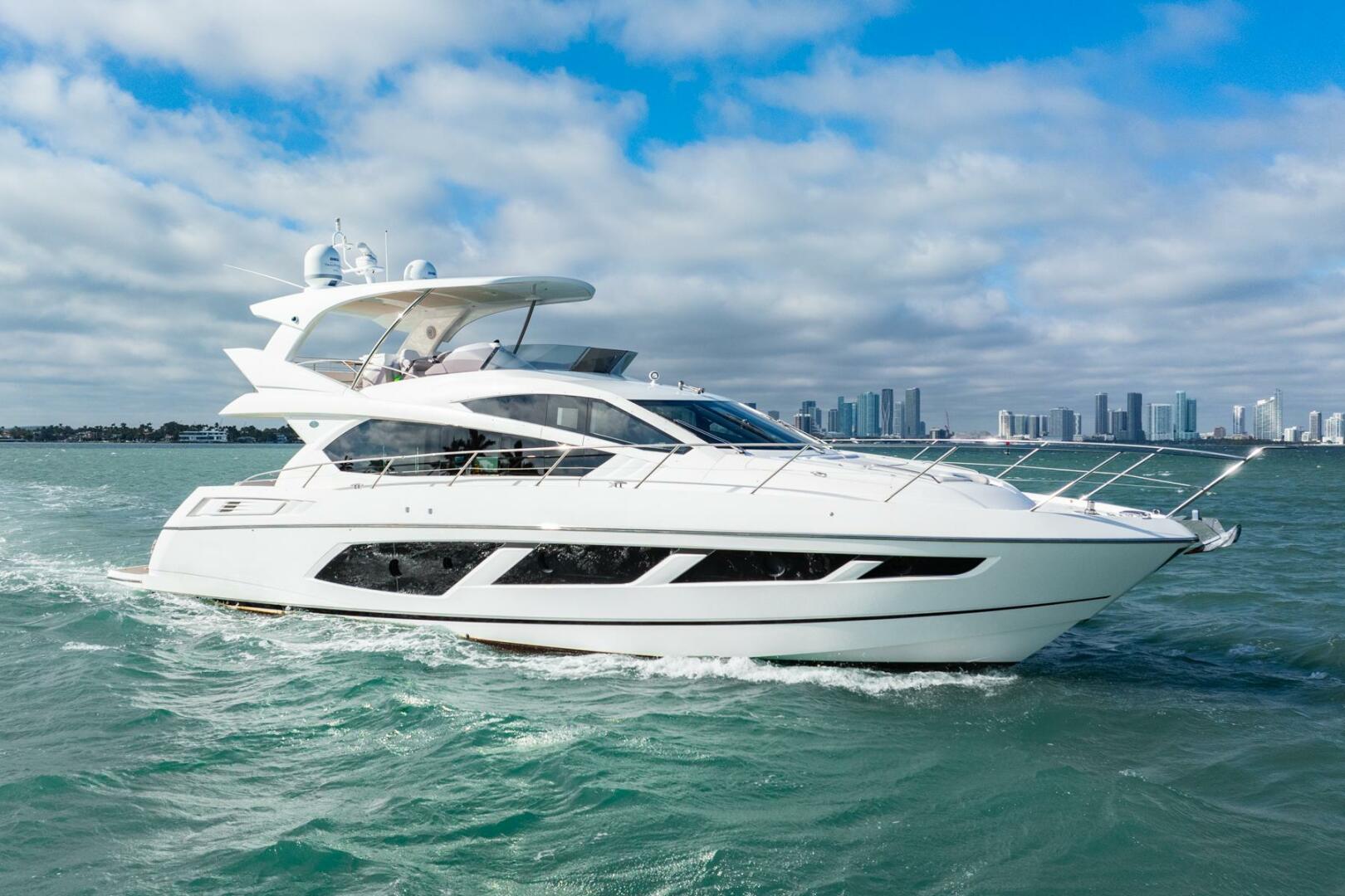 Sunseeker-Manhattan 65 2016 -Stuart-2016 Sunseeker Manhattan 65 yacht cruising on open water with city skyline backdrop.-5314541 | Thumbnail