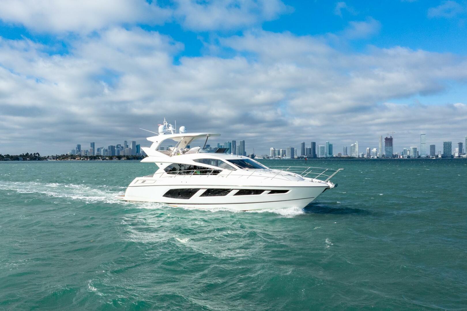 Sunseeker-Manhattan 65 2016 -Stuart-2016 Sunseeker Manhattan 65 yacht cruising on open water with city skyline backdrop.-5314539 | Thumbnail