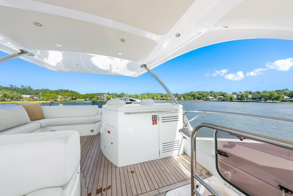 Sunseeker-Manhattan 65 2016 -Stuart-2016 Sunseeker Manhattan 65 yacht deck with seating, overlooking serene water and lush greenery.-5314549